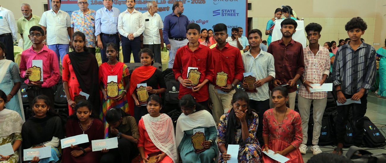 Students holding certificates and school kits at NMCT's Rojakootam event