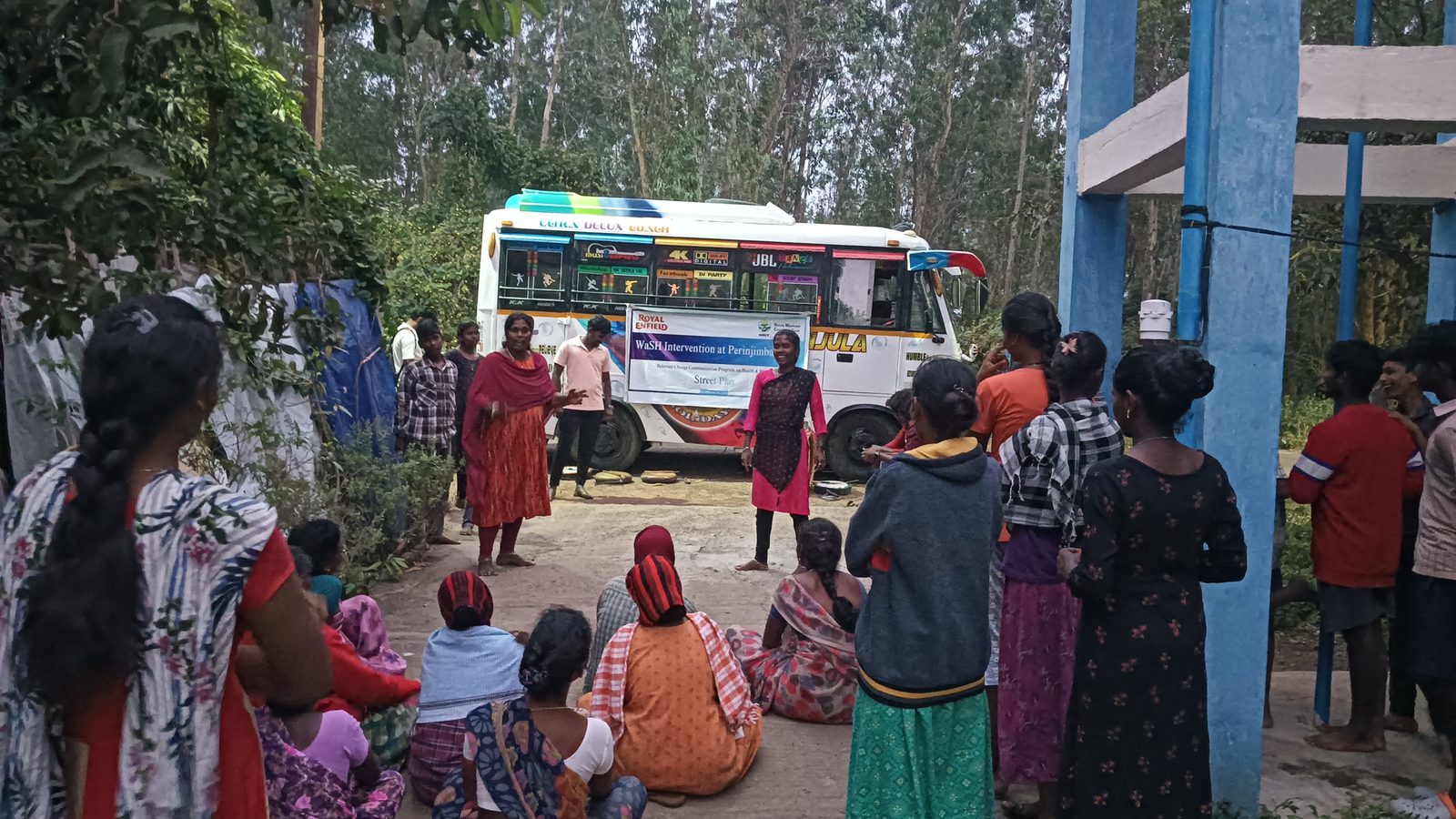 Community members waiting beside an NMCT mobile medical van at a health camp