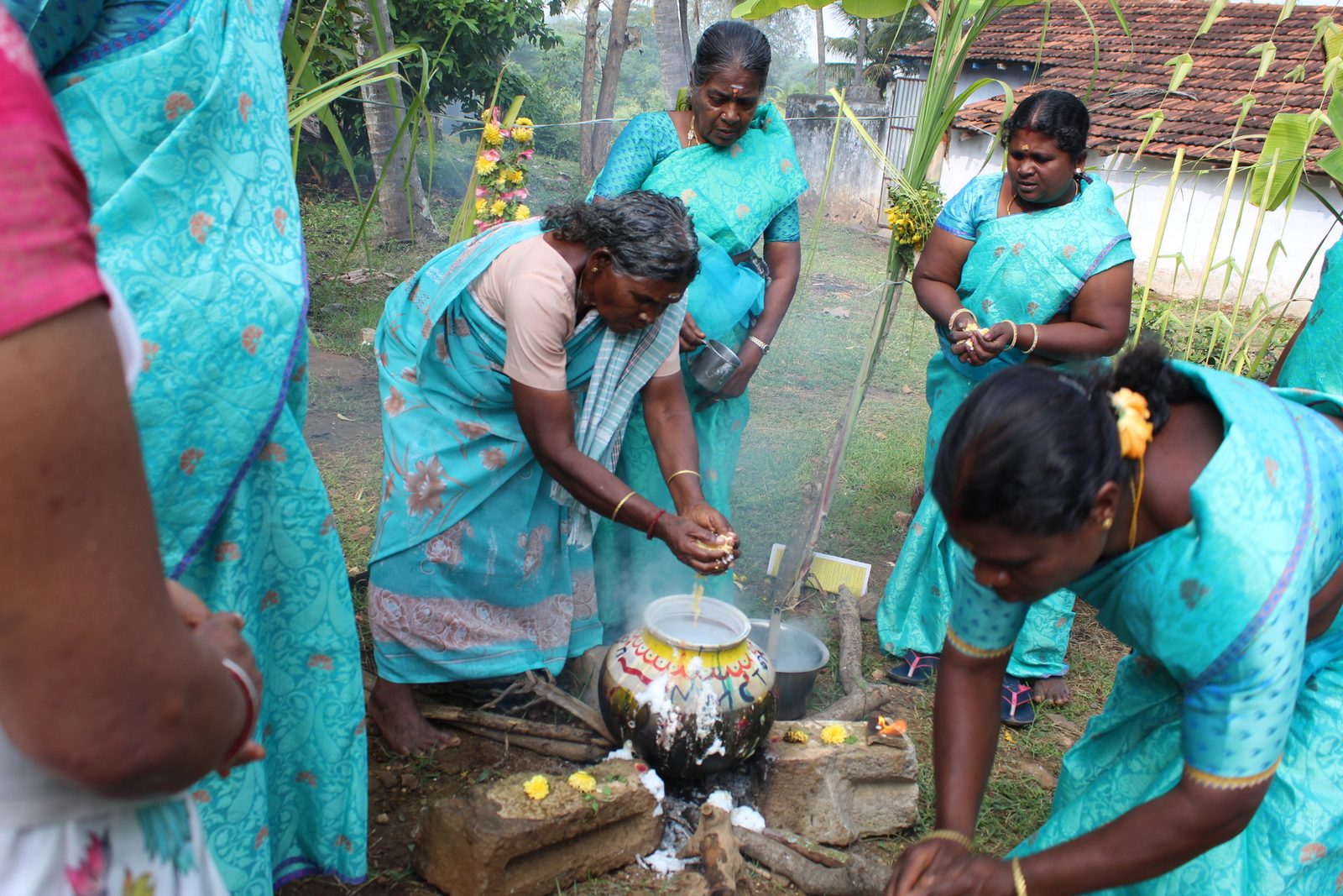 Women cooking Pongal together at an NMCT community celebration