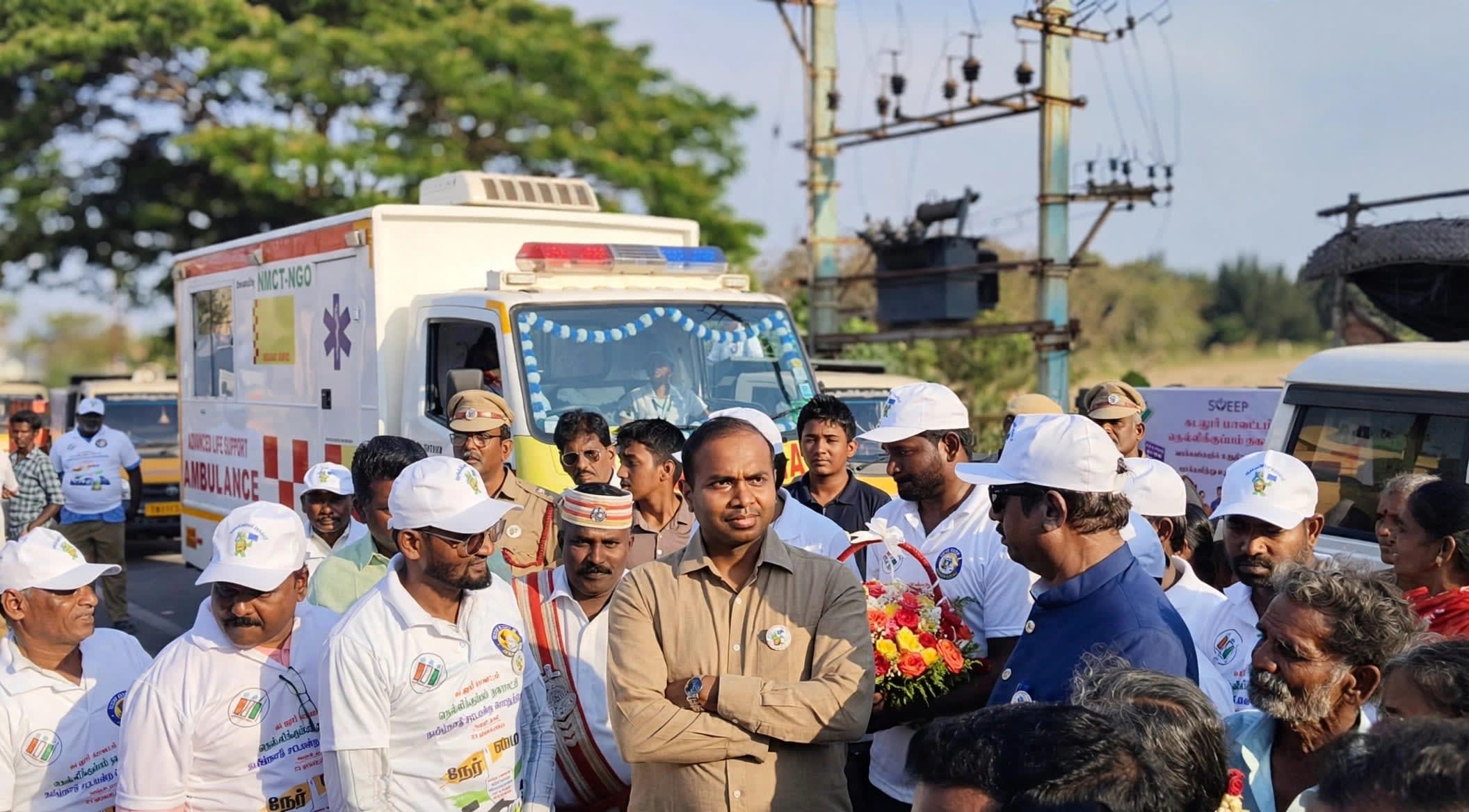 Guests and volunteers gathered in front of an NMCT advanced life support ambulance