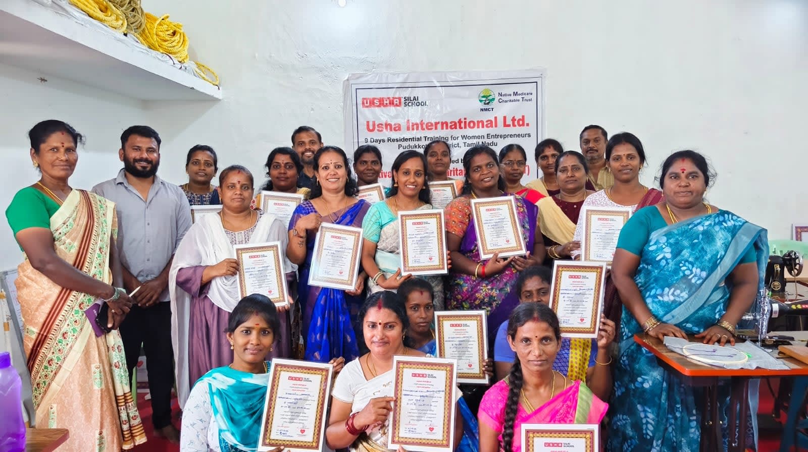Women holding their certificates after the USHA Silai School residential training